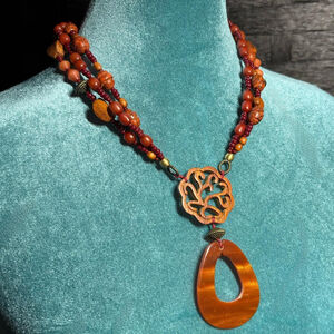 Orange, brown and red beaded vintage necklace with a wooden pendant